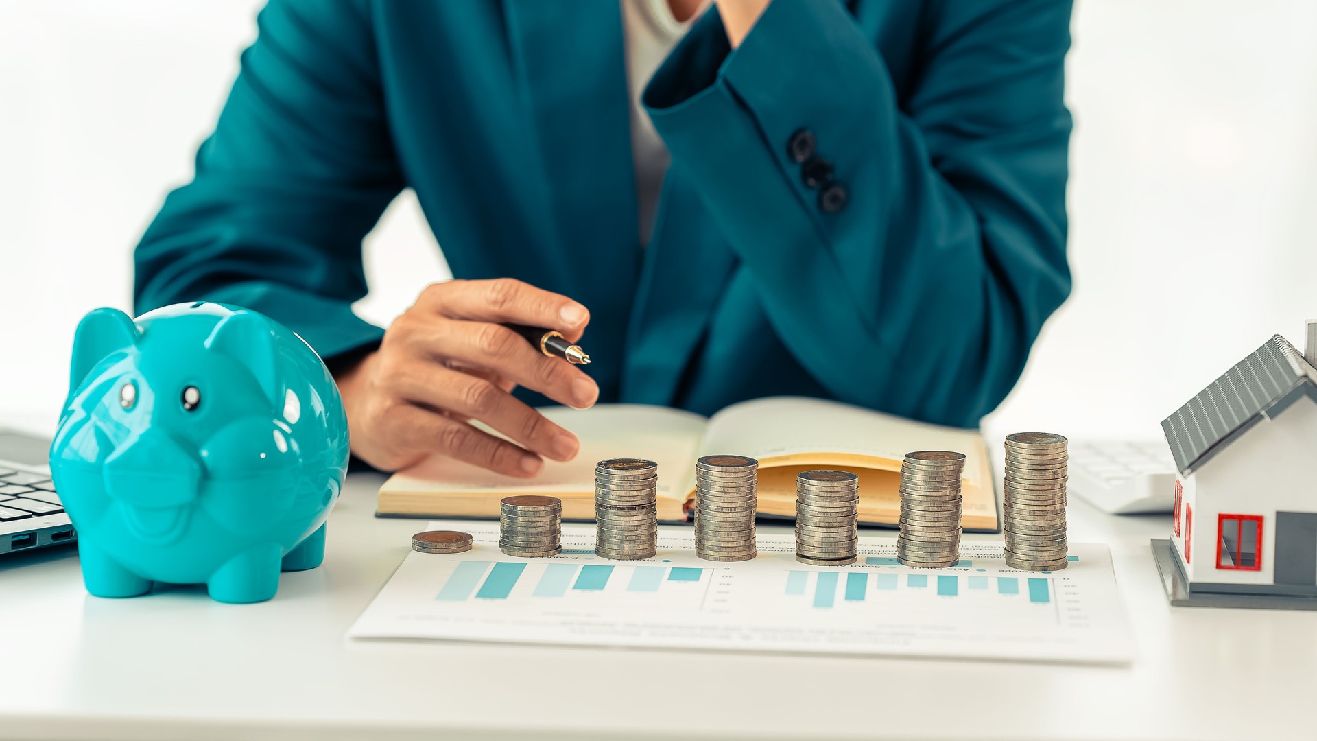 Piggy bank, coins and money bag with house model represent financial goals, to save money, plan to save money, savings, investment, financial freedom, business, hope for success.